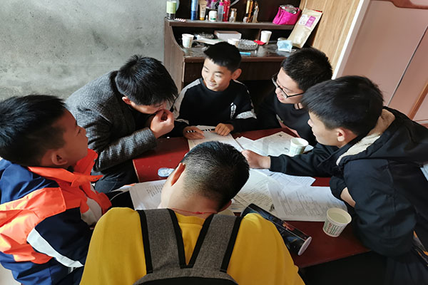 1219e65050814103ba0106593a10a0c7.jpg 志愿者老师们给孩子们讲解题目 (2).jpg